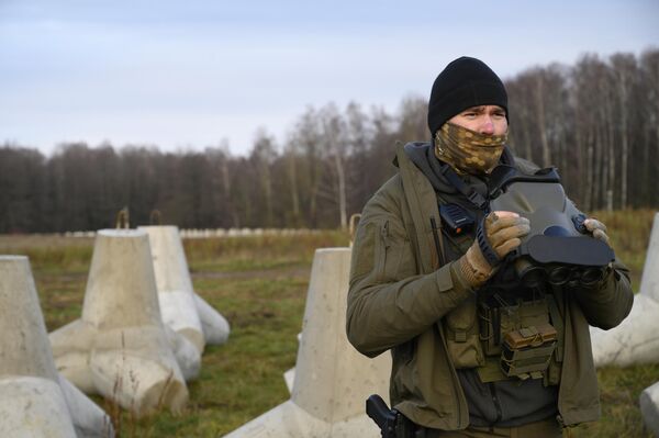 Польский пограничник использует тепловизионный бинокль, неся караул возле противотанковых бетонных укреплений. - Sputnik Беларусь