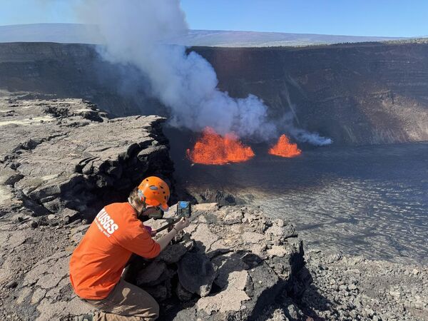 Геолог Гавайской вулканической обсерватории USGS проверяет веб-камеру, расположенную на краю кальдеры Килауэа. Сеть веб-камер на вершине вулкана Килауэа имеет решающее значение для мониторинга извержений в Национальном парке вулканов Гавайев. - Sputnik Беларусь