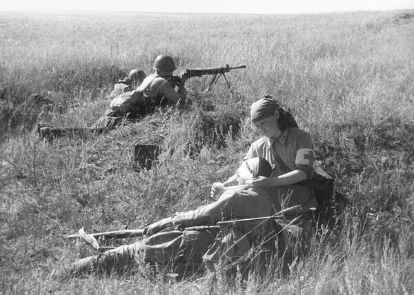 Санинструктор В. Смирнова оказывает помощь раненному на поле боя. Сталинград, район хутора Вертячий. - Sputnik Беларусь