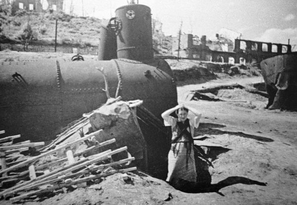 23 августа 1942 года немецкая воздушная армия обрушила свой бомбовый удар по улицам Сталинграда. Сотни вражеских самолетов, совершая один заход за другим, планомерно уничтожали жилые кварталы и мирное население. Жительница города у своего подземного укрытия на берегу Волги после фашистской бомбардировки. - Sputnik Беларусь