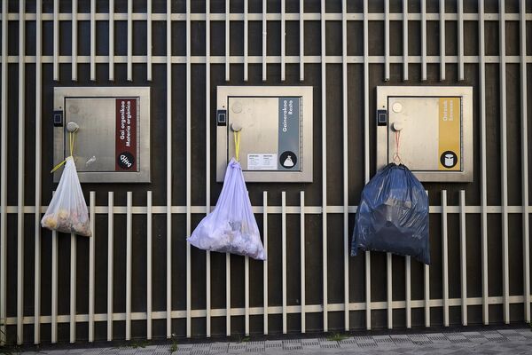 Мусорные мешки висят на дверцах электрических мусорных баков во время массового отключения электроэнергии в Памплоне, на севере Испании. - Sputnik Беларусь