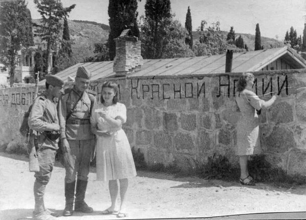 Крымская наступальная аперацыя была праведзена з 8 красавіка па 12 мая 1944 года.На фота: дзяўчына вызваленага Карэіза піша на сцяне "Слава доблестным бойцам Красной Армии", другая дзяўчына размаўляе з двума салдатамі. Крымская наступальная аперацыя была праведзена з 8 красавіка па 12 мая 1944 года.На фота: дзяўчына вызваленага Карэіза піша на сцяне "Слава доблестным бойцам Красной Армии", другая дзяўчына размаўляе з двума салдатамі. - Sputnik Беларусь