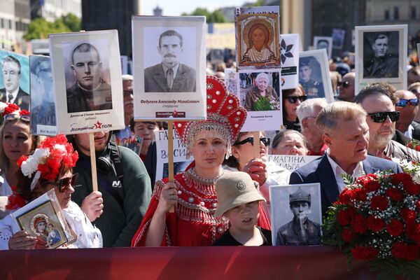 Жыхары Берліна, многія з іх – рускія, з партрэтамі родных, якія служылі ў Чырвонай Арміі падчас Другой сусветнай вайны, сабраліся на марш "Бессмертного полка" перад Брандэнбургскай брамай у 80-ю гадавіну заканчэння Другой сусветнай вайны. (Фота Шона Гэлапа/Getty Images) Жыхары Берліна, многія з іх – рускія, з партрэтамі родных, якія служылі ў Чырвонай Арміі падчас Другой сусветнай вайны, сабраліся на марш "Бессмертного полка" перад Брандэнбургскай брамай у 80-ю гадавіну заканчэння Другой сусветнай вайны. (Фота Шона Гэлапа/Getty Images) - Sputnik Беларусь