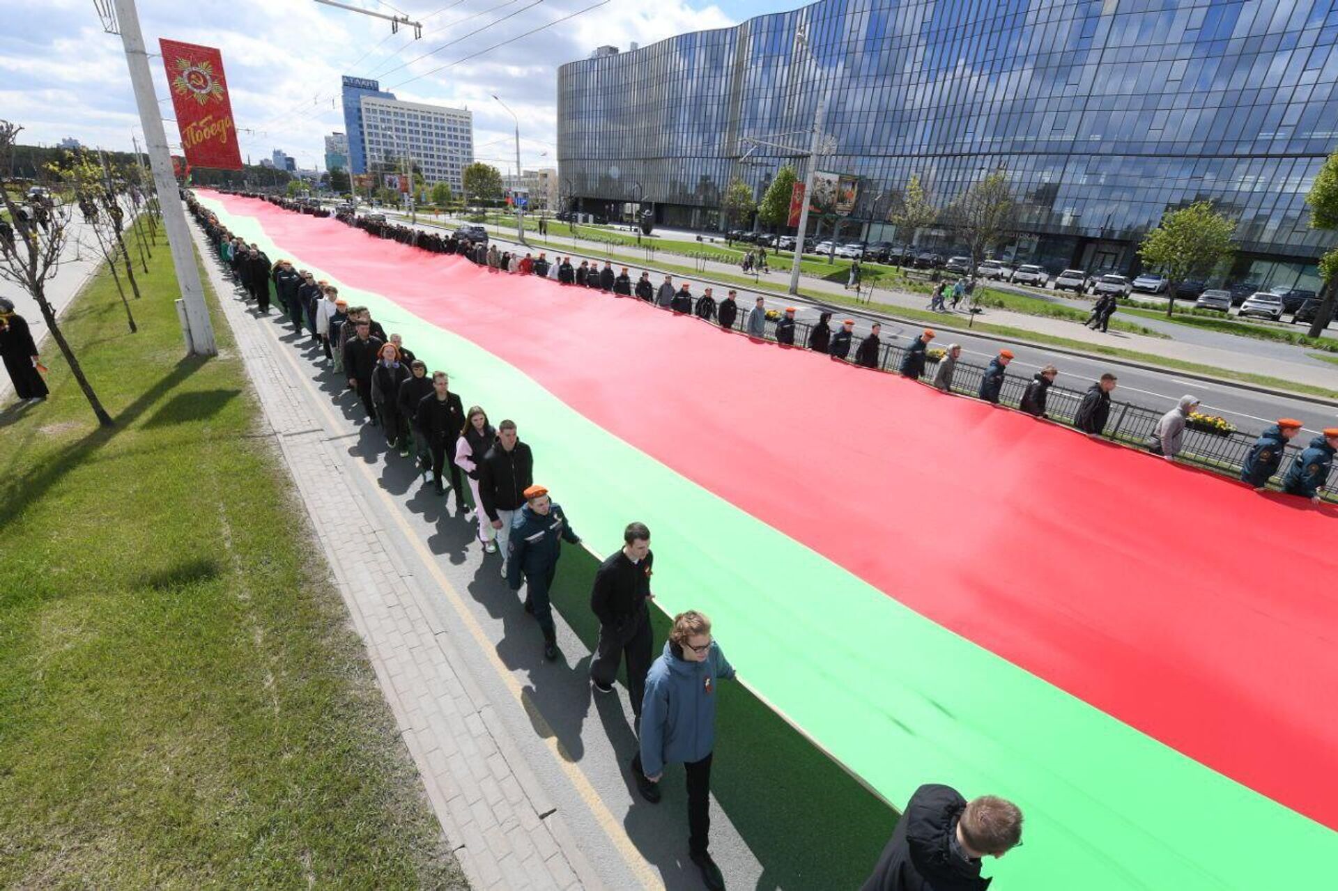 Государственный флаг Белоруссии длиною в полкилометра пронесли по Минску Государственный флаг Белоруссии длиною в полкилометра пронесли по Минску - Sputnik Беларусь, 1920, 11.05.2025
