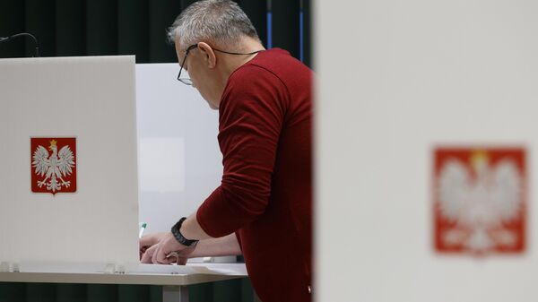 Мужчина голосует на выборах в Варшаве, Польша. Архивное фото - Sputnik Беларусь