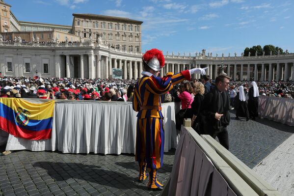 Вокруг места проведения интронизации приняты повышенные меры безопасности, сотрудники гражданской обороны регулируют передвижения паломников. На фото: швейцарский гвардеец указывает дорогу верующим. - Sputnik Беларусь