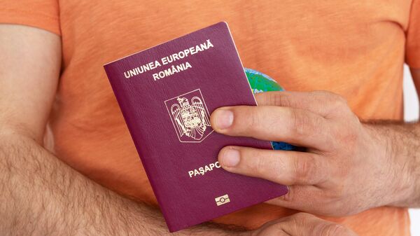 Мужчина держит в руках румынский паспорт - Sputnik Беларусь