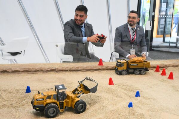 А группа компаний "Нацпроектстрой" развернула на полях ПМЭФ впечатляющий макет стройплощадки с грузовиками и экскаваторами на пульте управления. А группа компаний "Нацпроектстрой" развернула на полях ПМЭФ впечатляющий макет стройплощадки с грузовиками и экскаваторами на пульте управления. - Sputnik Беларусь