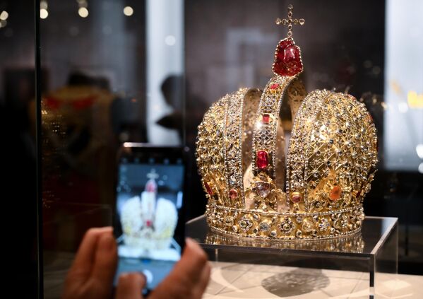 Корона императрицы Анны Иоанновны создана в 1730 году, в Москве, группой русских мастеров во главе с придворными ювелирами, золотых дел мастерами Самсоном Ларионовым и Никитой Милюковым.Серебряную позолоченную корону украшают 2500 алмазов, а также рубины и турмалины. Вес темно-красного турмалина под крестом – 100 граммов.  Высота короны 31,3 см. - Sputnik Беларусь