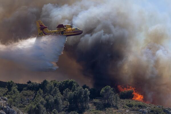 Самолеты-бомбардировщики типа Canadair национального флота гражданской безопасности работают во время пожара, бушующего в холмах к северу от Марселя, в районе Ле-Пен-Мирабо, Франция. - Sputnik Беларусь