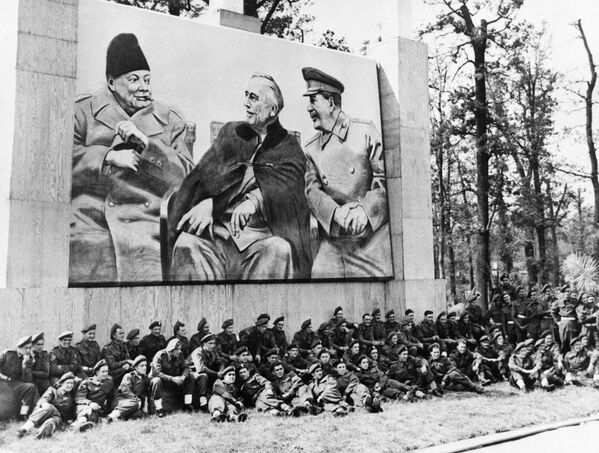 Брытанскі атрад дывізіі &quot;Пустынны пацук&quot; фатаграфуецца пад гіганцкай выявай лідараў &quot;Вялікай тройкі&quot; недалёка ад замка, дзе праходзіць Патсдамская канферэнцыя. - Sputnik Беларусь
