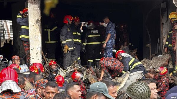 Пожарные осматривают обломки учебного самолета ВВС Бангладеш, упавшего на территорию школы в Дакке - Sputnik Беларусь