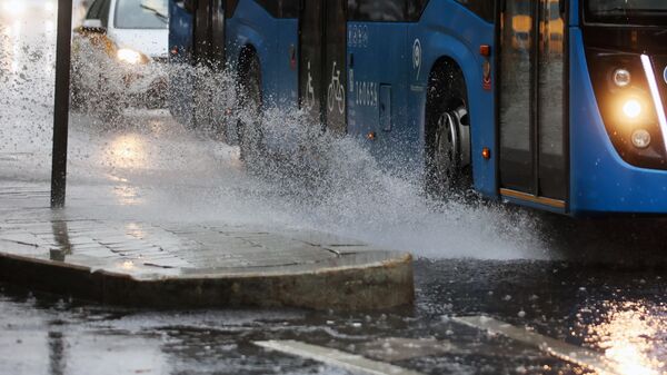Автобус движется по проезжей части дороги во время дождя - Sputnik Беларусь