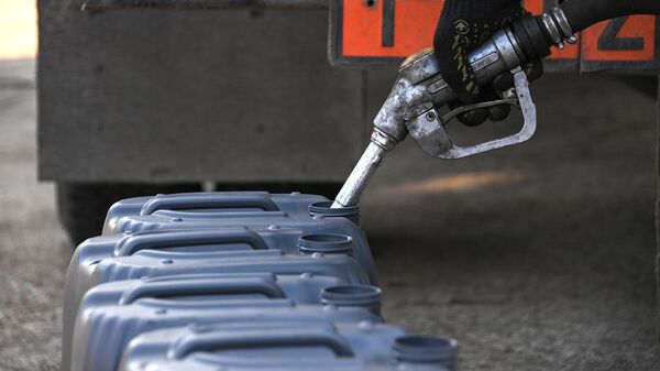 Сотрудник заполняет бензином канистры  - Sputnik Беларусь