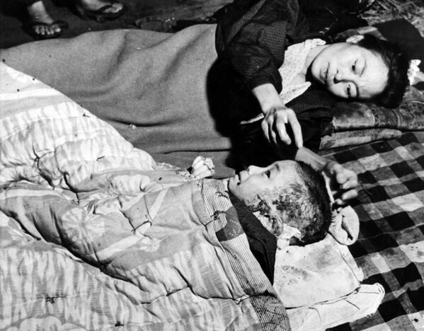 5 кастрычніка 1945 года. Маці даглядае сваё параненае дзіця, якое стала ахвярай атамнай бамбардзіроўкі Хірасімы 6 жніўня. 5 кастрычніка 1945 года. Маці даглядае сваё параненае дзіця, якое стала ахвярай атамнай бамбардзіроўкі Хірасімы 6 жніўня. - Sputnik Беларусь