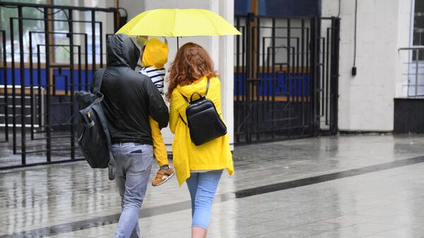 Семейная пара с ребенком во время дождя  - Sputnik Беларусь