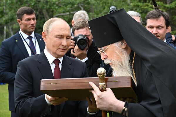 После возложения цветов на мемориальном кладбище в Анкоридже Путин пообщался с американским православным священником владыкой Алексием и подарил ему две иконы. - Sputnik Беларусь