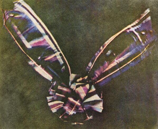 Первая цветная фотография – 1861 год. Автор этой работы – шотландский физик Джеймс Клерк Максвелл. На снимке, который называется &quot;Тартановая лента&quot; (The Tartan Ribbon) запечатлен бант из клетчатой шотландки на фоне черного бархата. Максвелл попросил фотографа Томаса Саттона трижды сфотографировать клетчатую ленту, каждый раз используя разный цветной фильтр (красный, зеленый или сине-фиолетовый) перед объективом. Три фотографии были проявлены, распечатаны на стекле, а затем спроецированы на экран тремя разными проекторами, каждый из которых был оснащен тем же цветным фильтром, который использовался для съемки. При наложении на экран три изображения образовывали полноцветное изображение.Трехцветный подход Максвелла лежит в основе почти всех форм цветной фотографии, будь то пленочная, аналоговая видео или цифровая. - Sputnik Беларусь