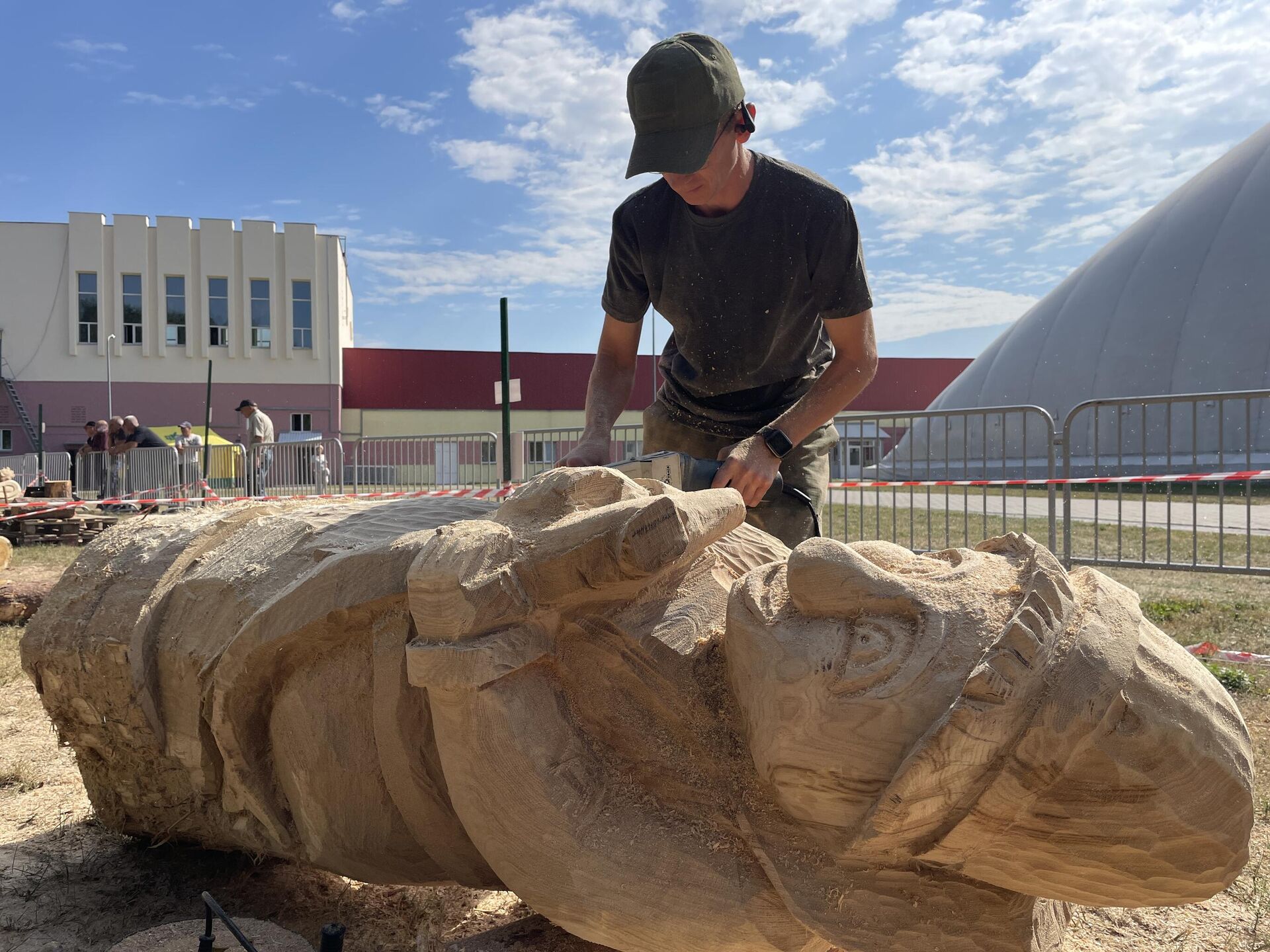 На фестивале деревянных скульптур в Гомеле по мотивам сказок и легенд 13 участников вырезают скульптуры из двухметровых бревен. Мастер из Октябрьского района Андрей Афанасенко вырезает Емелю из По щучьему велению - Sputnik Беларусь, 1920, 06.09.2025