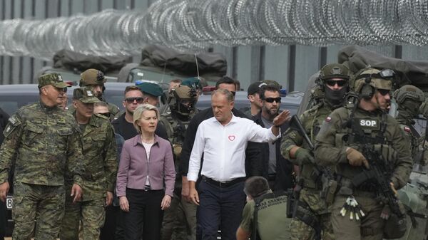 Премьер-министр Польши Дональд Туск (в центре справа) и председатель Европейской комиссии Урсула фон дер Ляйен (в центре слева) беседуют с сотрудниками Пограничной службы во время визита на польско-белорусскую границу в Крынках - Sputnik Беларусь