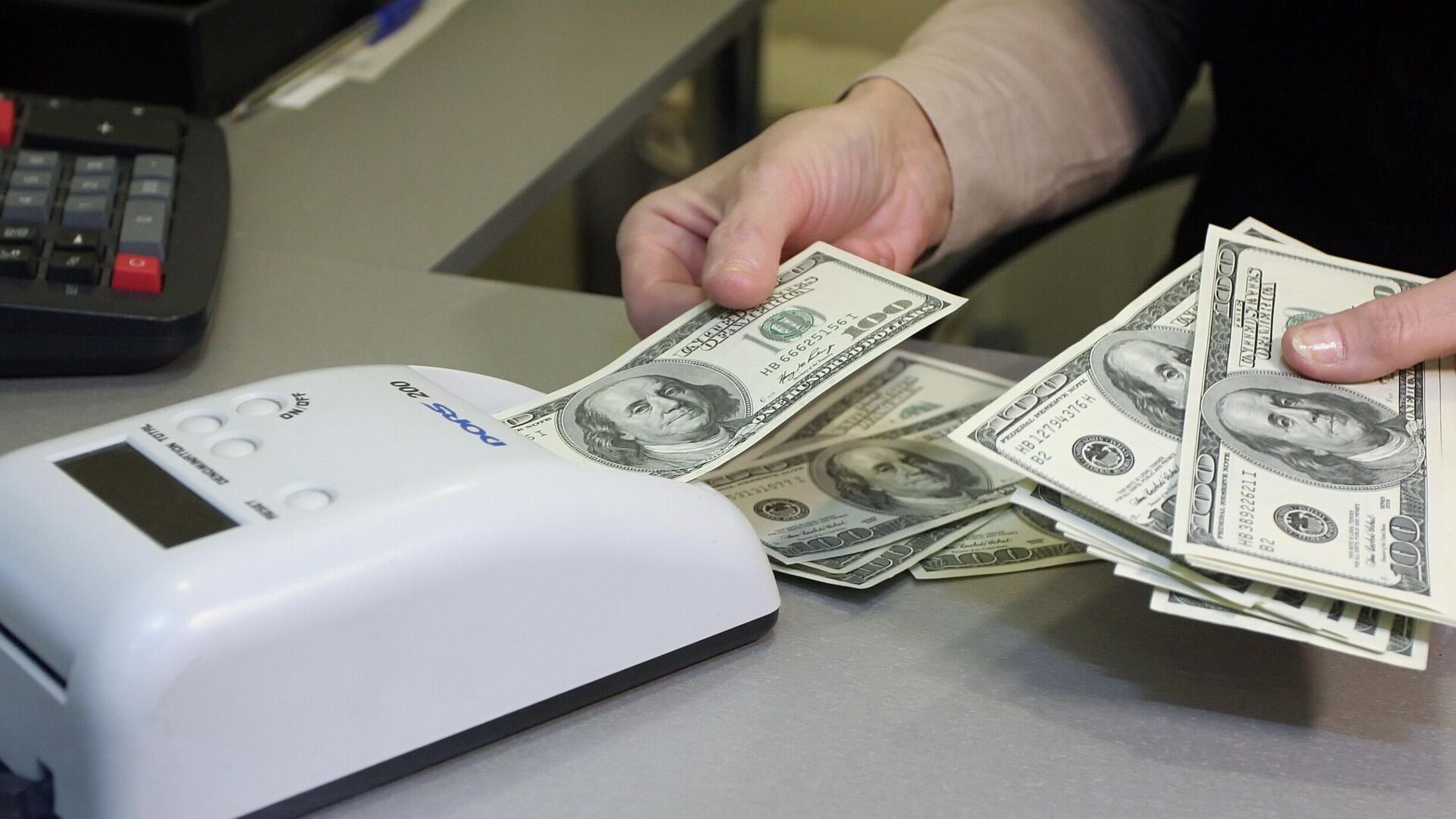 Проверка долларов на подлинность в пункте обмены валюты 