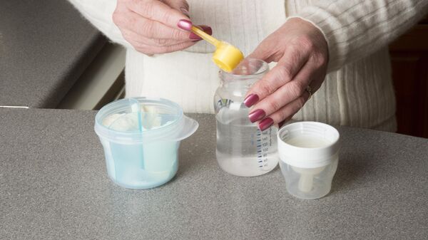 Женщина готовит детскую смесь из сухого молока - Sputnik Беларусь