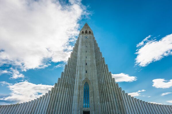 Церковь Хатльгримскиркья (Hallgrímskirkja) — это лютеранская церковь и один из главных символов Рейкьявика, столицы Исландии.Церковь расположена на вершине холма в центре города и известна своим уникальным архитектурным дизайном, напоминающим извержение вулкана, а также своей высокой башней, с которой открывается панорамный вид на город. - Sputnik Беларусь