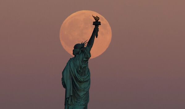 Полная Луна восходит за статуей Свободы в Нью-Йорке. - Sputnik Беларусь