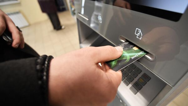 Мужчина проводит денежные операции с помощью банкомата  - Sputnik Беларусь