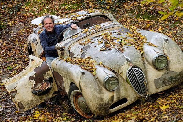Коллекционер автомобилей Михаэль Фрёлих в автомобиле Jaguar XK120 в своем частном парке. Именно эта машина стала первым экспонатом  в Парке автомобильных скульптур. Чтобы краска побыстрее испортилась, Фрёлих даже вымазал ее йогуртом.