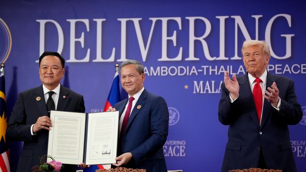 Премьер-министр Таиланда Анутин Чарнвиракул и премьер-министр Камбоджи Хун Манет пожимают друг другу руки после подписания мирного соглашения между Камбоджей и Таиландом. Президент США Дональд Трамп принимает участие в церемонии - Sputnik Беларусь