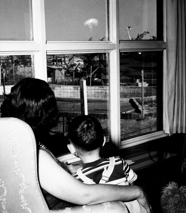 За выпрабаваннямі ў Невадзе можна было назіраць і з Лас-Вегаса. На фота Жаклін Бак і яе маленькі сын глядзяць з акна на &quot;ядзерны грыб&quot; 8 мая 1953 года. - Sputnik Беларусь