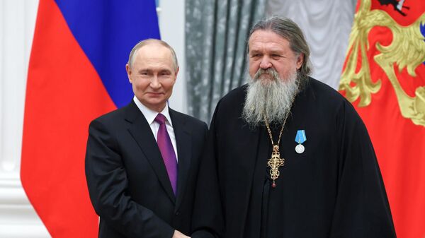 Президент РФ Владимир Путин и протоиерей, клирик Свято-Елисаветинского женского монастыря Минской епархии Белорусского Экзархата Московского Патриархата Андрей Лемешонок, награжденный медалью Пушкина, на церемонии вручения в Екатерининском зале Кремля государственных наград и премий президента РФ за вклад в укрепление единства российской нации - Sputnik Беларусь