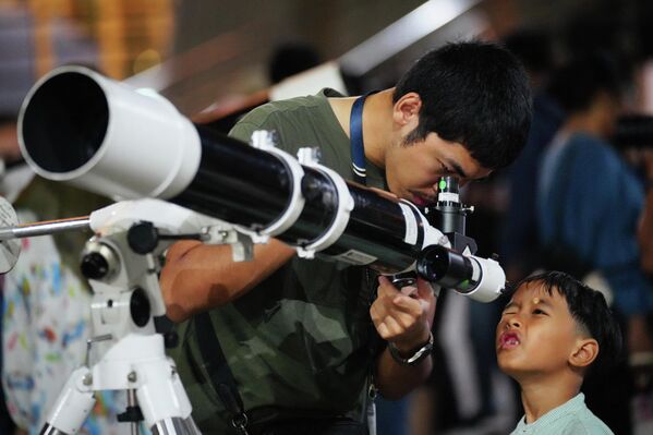 Мужчина наблюдает за восходом Луны в Джакарте, Индонезия.