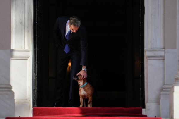Премьер-министр Греции Кириакос Мицотакис со своей собакой по кличке Пинат в особняке Максимоса в Афинах (официальной резиденции главы правительства) ожидает прибытия президента Румынии Клауса Йоханниса (2 декабря 2022 года).