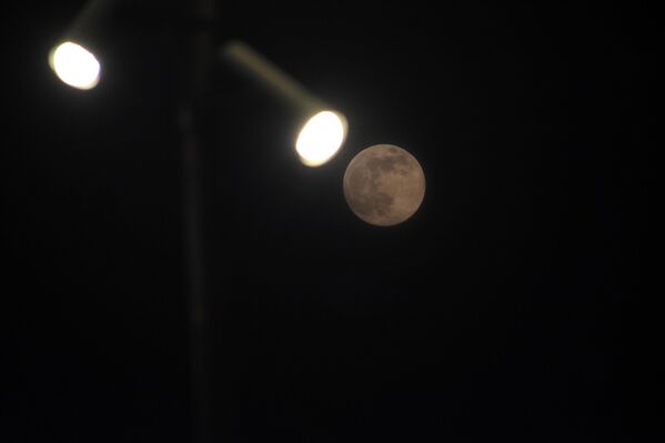 Последняя суперлуна 2025-го восходит за уличными фонарями в Шринагаре (Кашмир, Индия). - Sputnik Беларусь