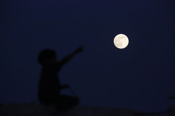 Холодная суперлуна видна над Аль-Мугракой в ​​центральной части Газы, которая сильно пострадала в результате израильских атак. - Sputnik Беларусь