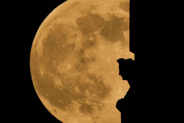 Холодная луна поднимается над статуей на вершине башни Национального музея и мемориала Первой мировой войны в Канзас-Сити, штат Миссури, США. - Sputnik Беларусь