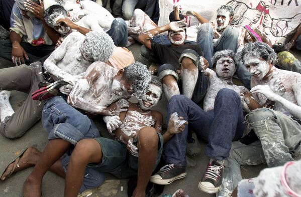 Восточнотиморские демонстранты с раскрашенными в белый цвет лицами на демонстрации