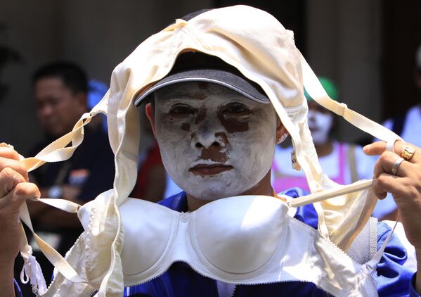 Женщина с раскрашенным в белый цвет лицом во время митинга в Маниле