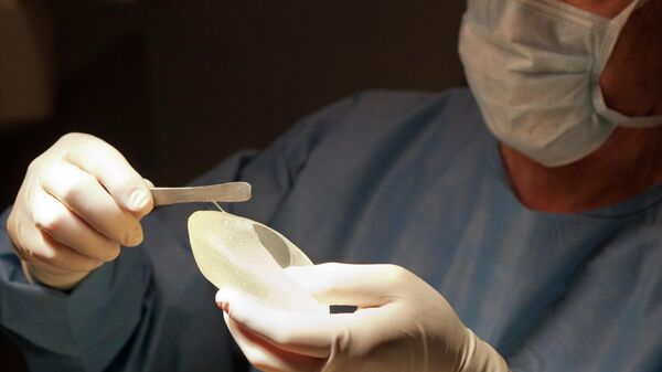 Силиконовый имплант в руках хирурга  - Sputnik Беларусь