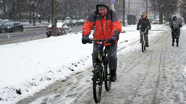Прохожие и велосипедисты во время снегопада Прохожие и велосипедисты во время снегопада - Sputnik Беларусь