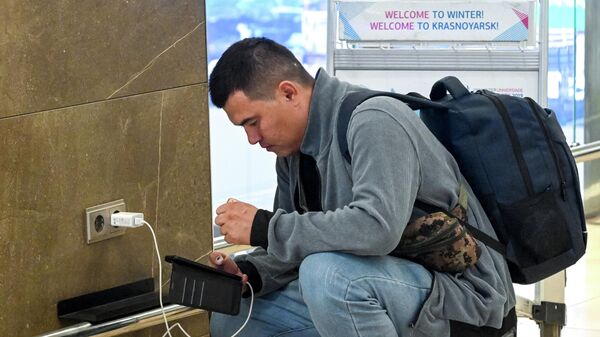 Пасажыр зараджае смартфон у аэрапорце, архіўнае фота - Sputnik Беларусь