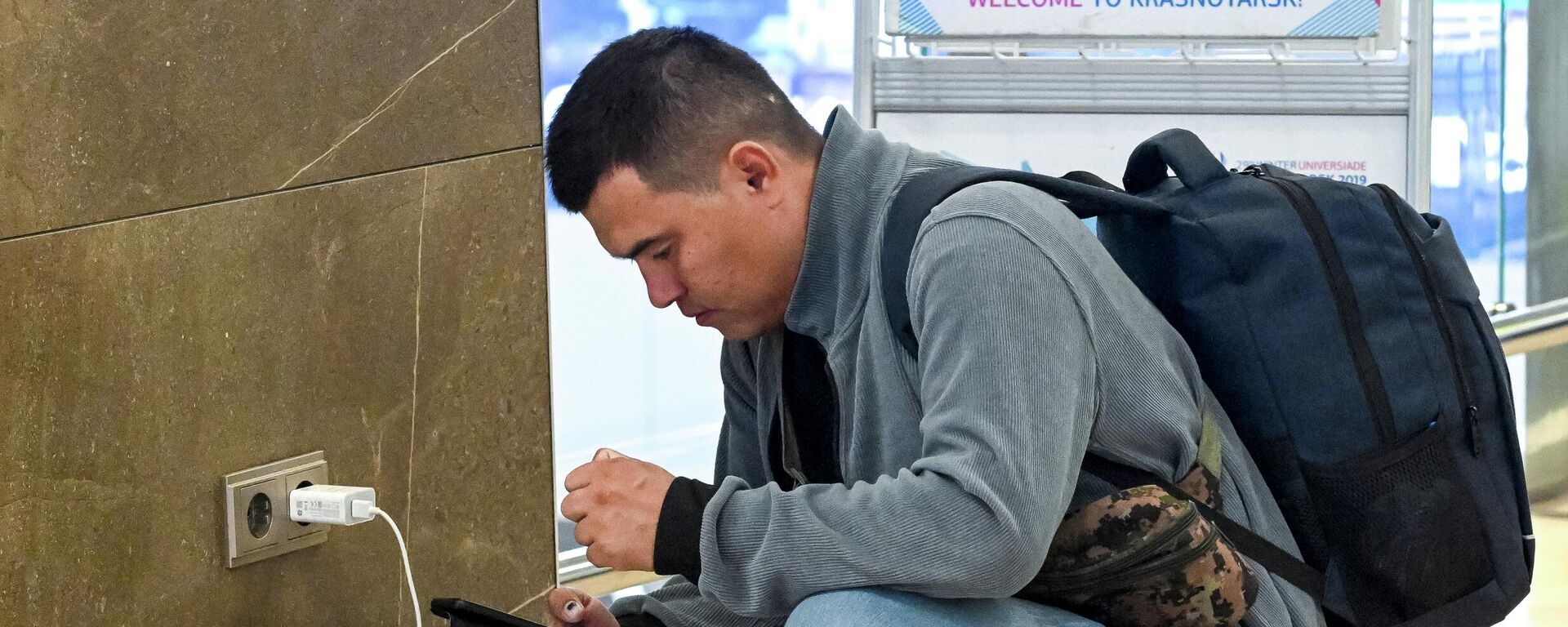 Пасажыр зараджае смартфон у аэрапорце, архіўнае фота - Sputnik Беларусь, 1920, 18.12.2025