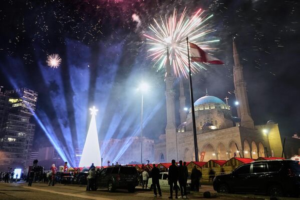 Зрители наблюдают за фейерверком в честь зажжения гигантской рождественской елки, установленной перед мечетью Мухаммеда аль-Амина на Площади Мучеников в центре Бейрута, Ливан. - Sputnik Беларусь