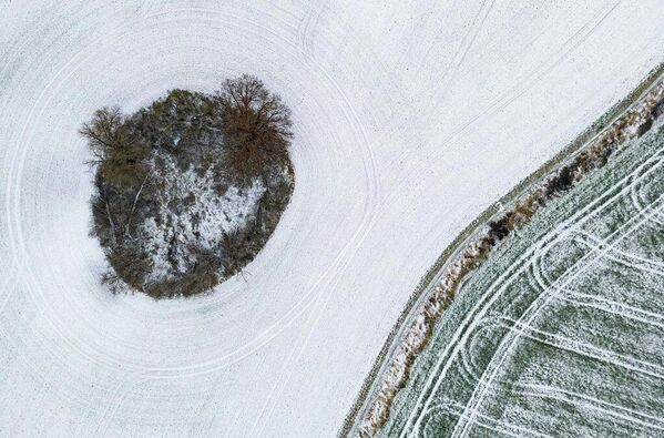 Снег на поле ранним утром в восточном Бранденбурге лежит небольшой снег (фото с дрона). 