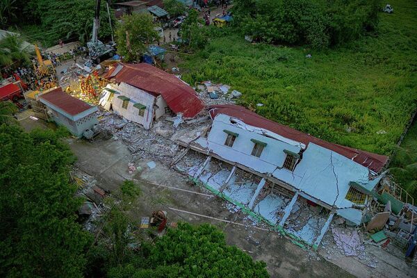 Cпасатели ищут выживших под обломками обрушившегося жилого здания в городе Бого в провинции Себу на Филиппинах - Sputnik Беларусь