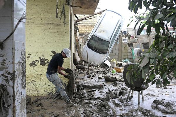 Мужчина убирает грязь в одном из районов, пострадавших от проливных дождей в Поса-Рика-де-Идальго в мексиканском штате Веракрус (октябрь 2025 года). - Sputnik Беларусь