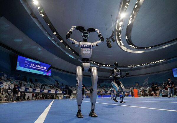 Человекоподобный робот заигрывает с публикой во время показательного выступления на открытии Всемирных игр человекоподобных роботов в Пекине (14 августа 2025 года). Китай позиционировал этот чемпионат как первый в своем роде. - Sputnik Беларусь