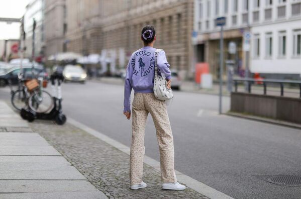Немецкая модель Селин Бетманн в поло Ralph Lauren на улице в Берлине в 2022 году. Знаменитая эмблема Ralph Lauren с игроком в поло верхом на лошади появилась в 1971 году на женской коллекции рубашек, символизируя элитарность, стиль и "американский образ жизни" аристократичного спорта поло, хотя сам Ральф Лорен никогда не играл в поло. - Sputnik Беларусь
